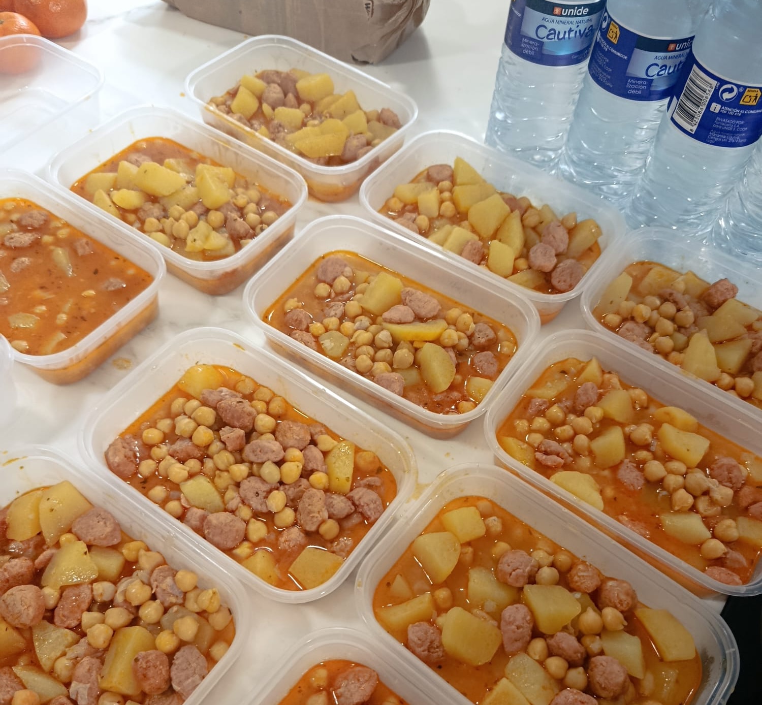 Voluntarios preparando comida para llevar a los pobres